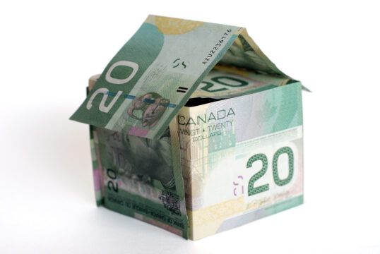 20 Canadian dollar banknotes folded into a house shape representing real estate and mortgage finance, emphasizing financial options and homeownership opportunities.